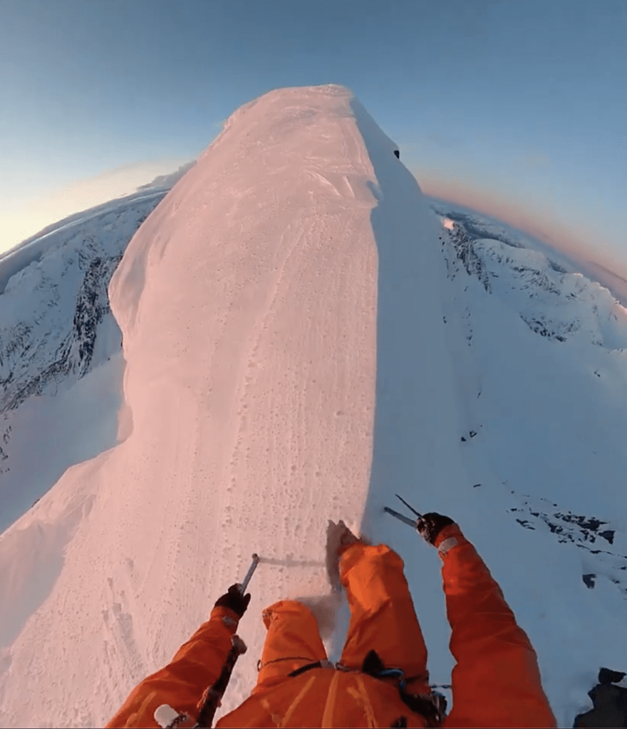 A man on top of high mountain filming a 360 video
